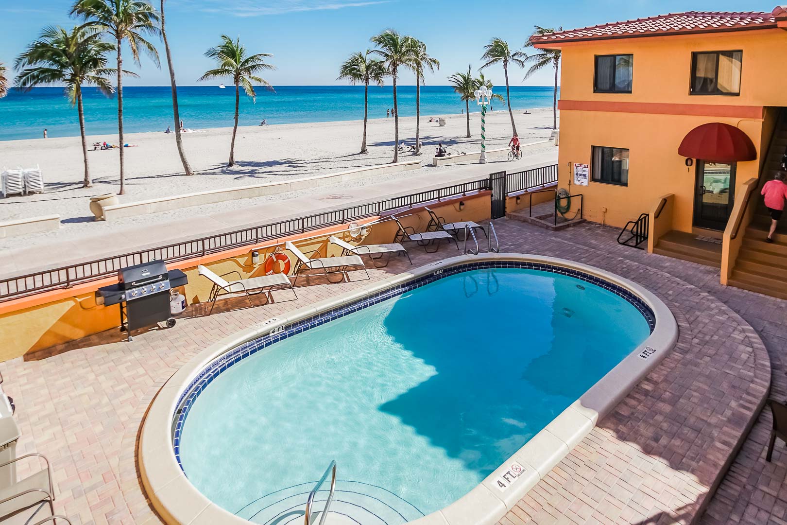 A scenic outdoor swimming pool by the beach at VRI's Hollywood Sands Resort in Hollywood, Florida.